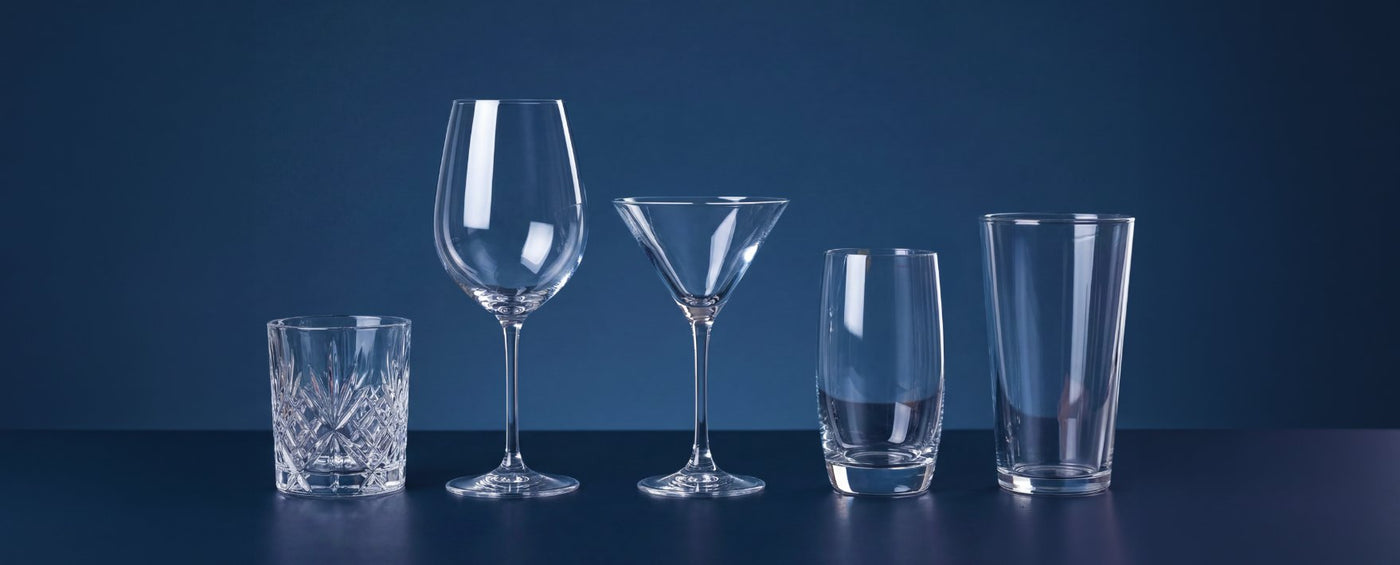 Five sparkling clean glasses polished by Sparkléve lined up on a dark blue surface